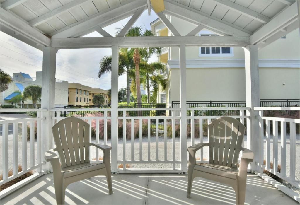 dos sillas sentadas en un porche en Ideal Beach Cottage Steps to Siesta Beach and Village Shops and Restaurants, en Siesta Key