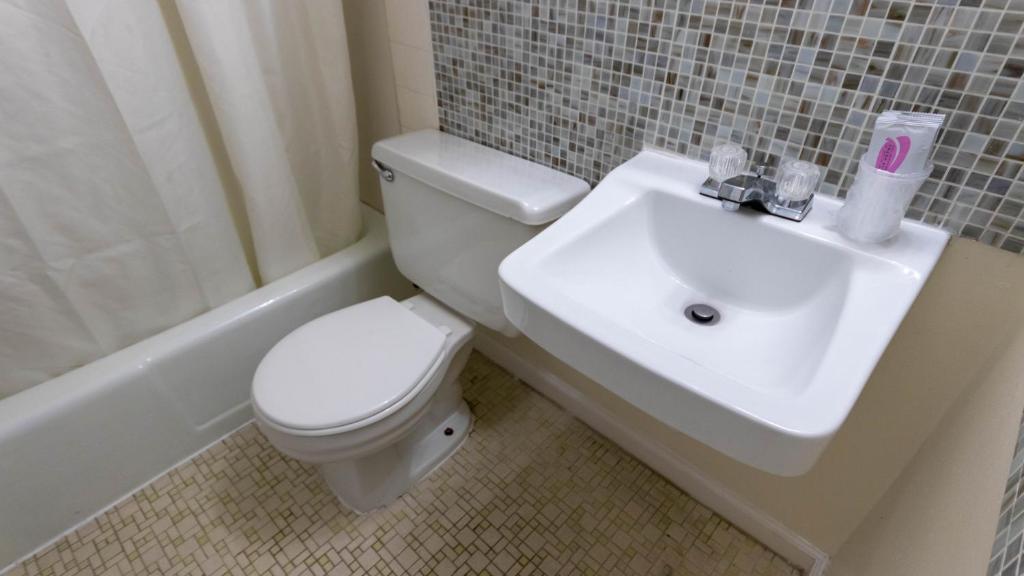 a bathroom with a white toilet and a sink at Rideau Oceanfront Motel in Ocean City