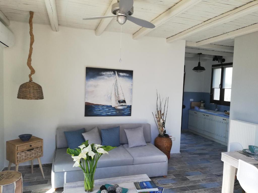 a living room with a couch and a ceiling fan at Anio Residence - Rustic Modern with Sea and Mountain View Terrace in Svoronata