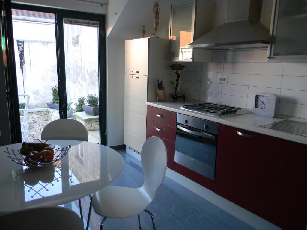 a kitchen with a glass table and a table and chairs at Apartments Lorenco in Tisno