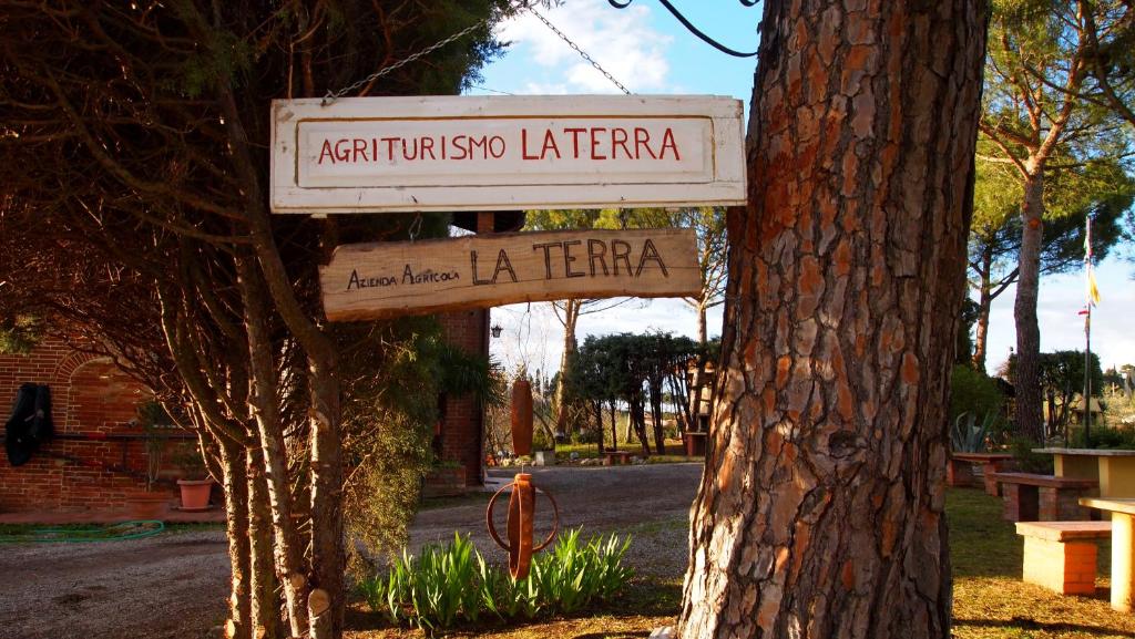 Ein Schild hängt von einem Baum neben einem Baum in der Unterkunft Agriturismo La Terra in Valiano