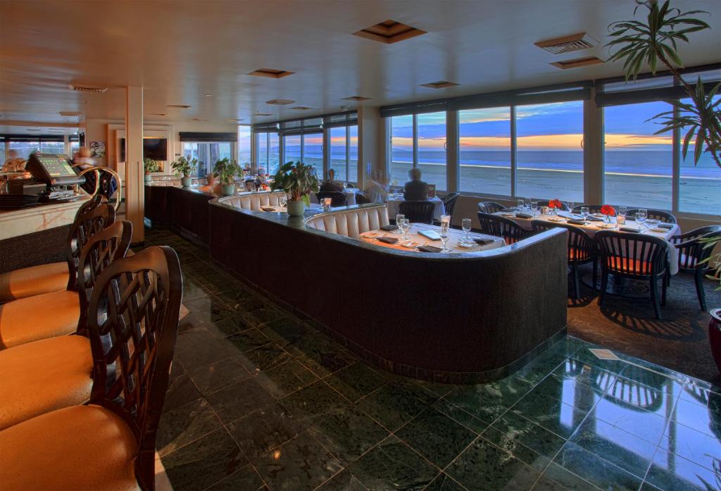 a restaurant with a bar with a view of the ocean at SeaVenture Beach Hotel in Pismo Beach
