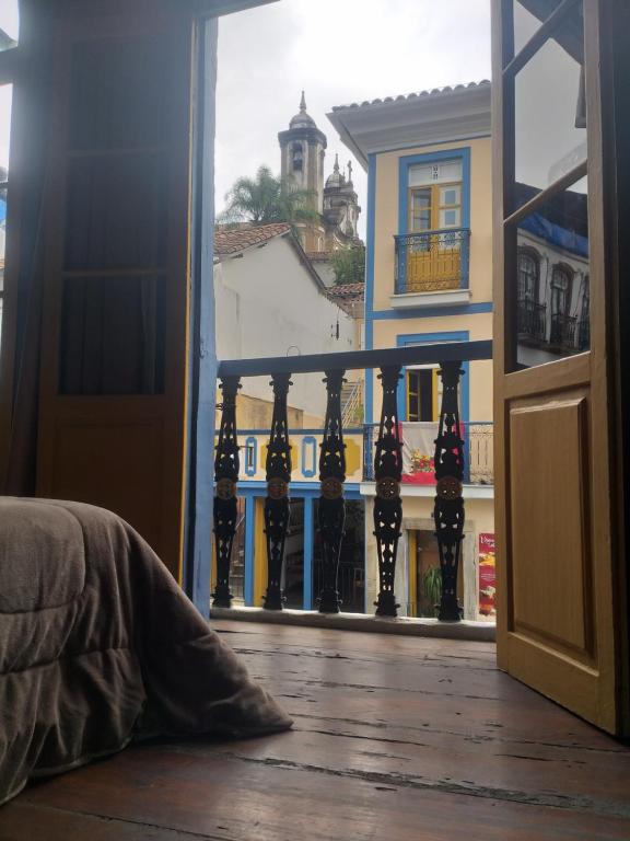 een open deur naar een balkon met uitzicht op een gebouw bij Casa Colonial in Ouro Preto