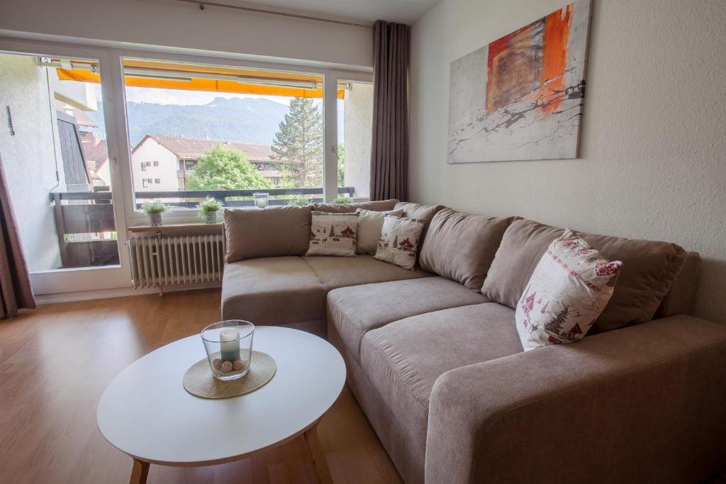 salon z kanapą i stołem w obiekcie Alpenzauber Whg.25 w Garmisch Partenkirchen