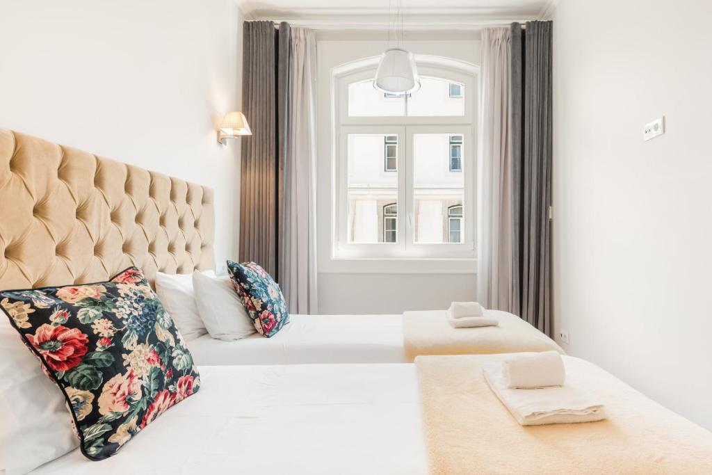 sypialnia z dużym białym łóżkiem i oknem w obiekcie Augusta Street 213 - 3 Dto - Your Home in Lisbon w Lizbonie