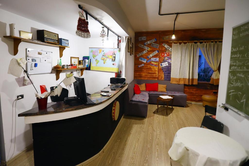 a room with a table and a wall with pictures on it at D1 Hostel in Tirana