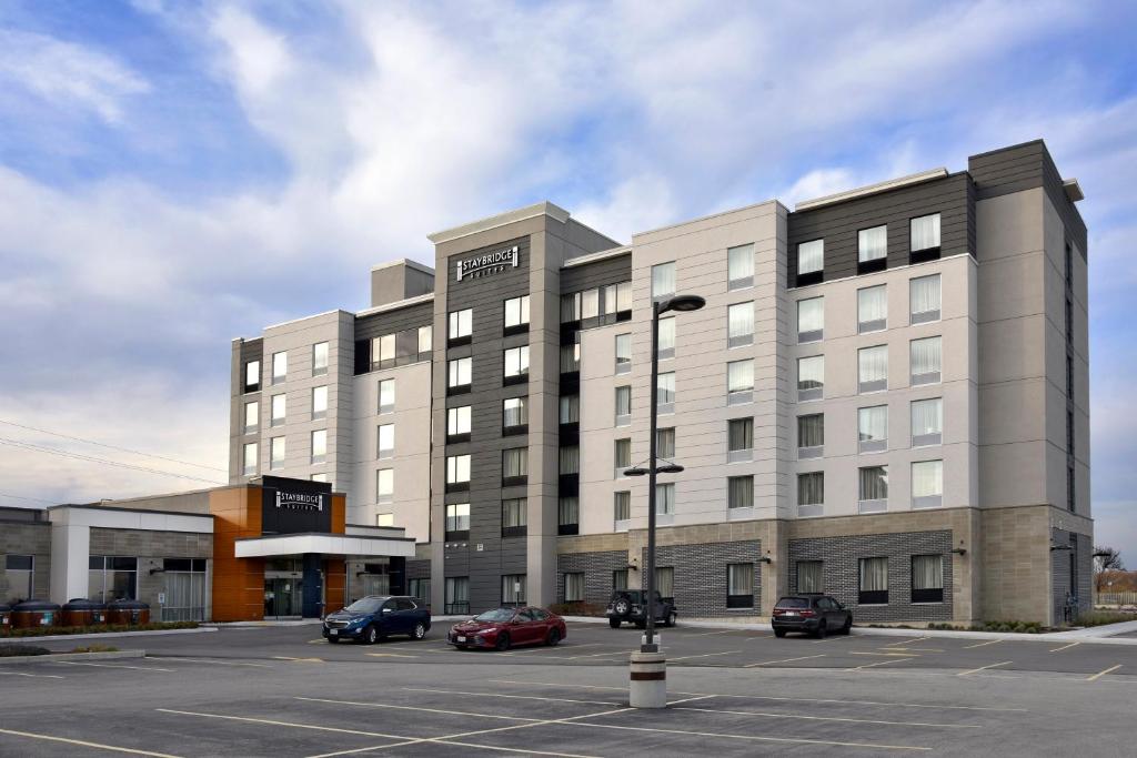 un gran edificio con coches estacionados en un estacionamiento en Staybridge Suites - Waterloo - St. Jacobs Area, en Waterloo