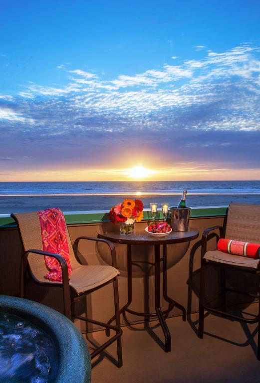 a balcony with a table and chairs and the ocean at SeaVenture Beach Hotel in Pismo Beach