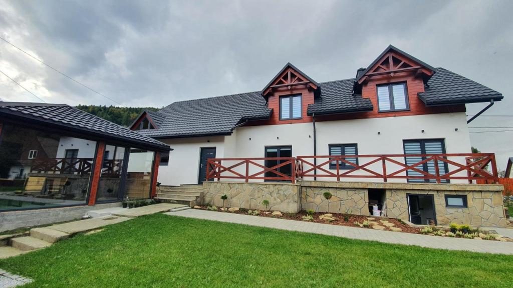 a large white house with a black roof at Dom Pod Groniem in Rzyki