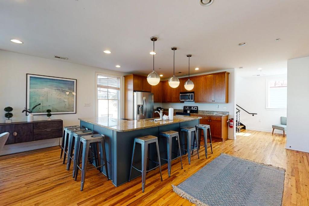a kitchen with a blue island with bar stools at Contemporary Home in Perfect Location - 207 B St Philip Street in Charleston