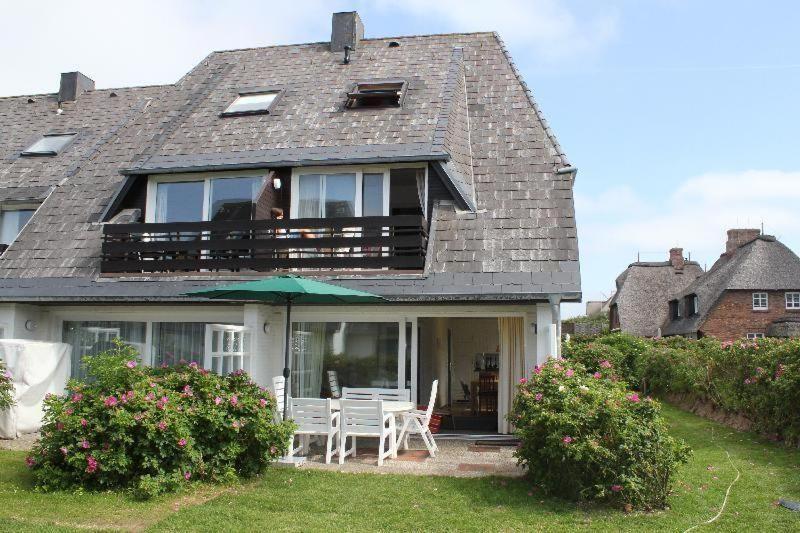 Casa con patio con sillas y sombrilla en Haus-Carola-App-11-Sylter-Seestern en Wenningstedt