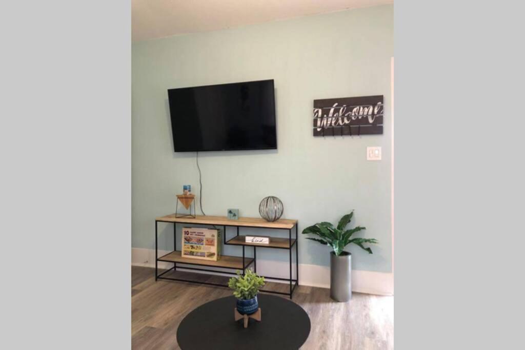 a living room with a flat screen tv on a wall at The Comfi Coral - 2 Bed Apartment Home Studio B in Baytown