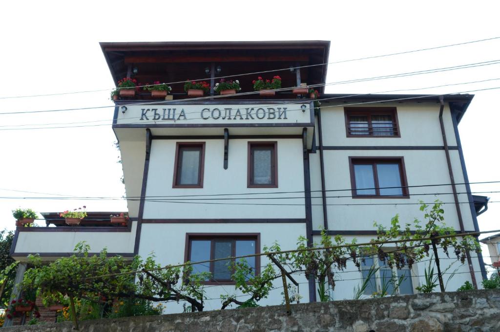 a white building with a sign on it at Къща за Гости Солакови ** in Devin