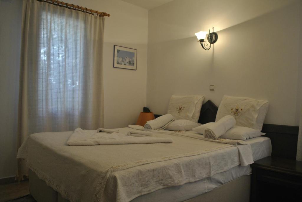 a bedroom with a bed with white sheets and a window at Diana Aparts in Kalkan