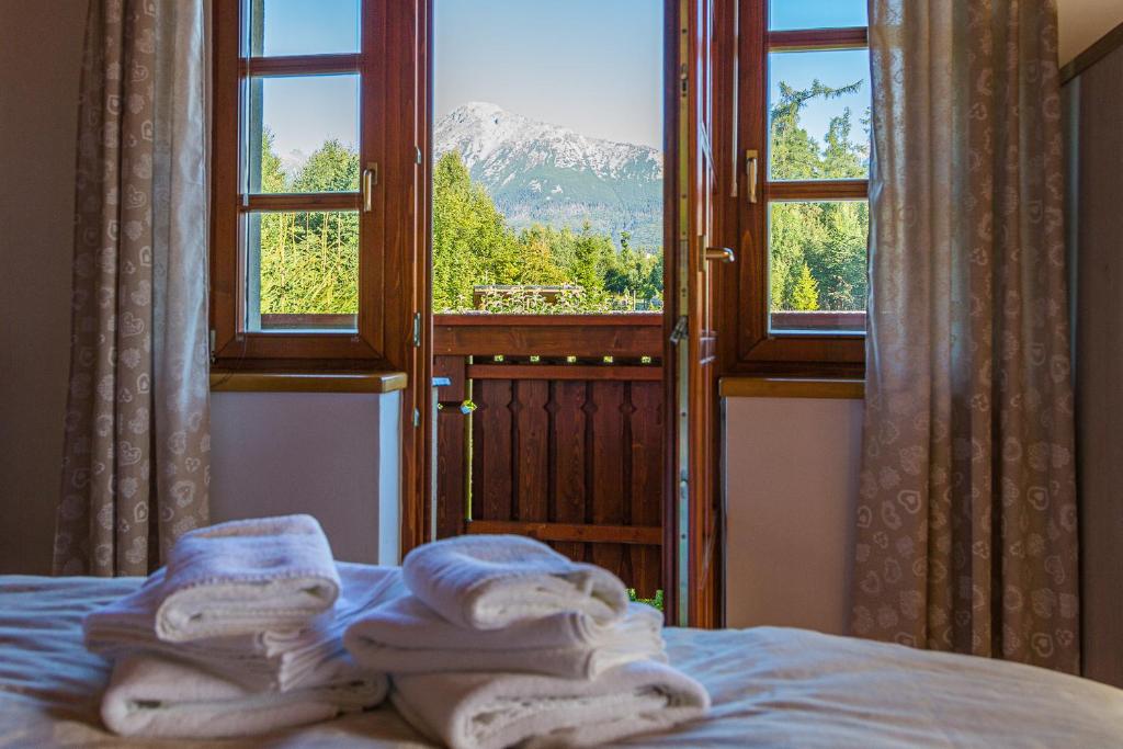 sypialnia z ręcznikami na łóżku przed oknem w obiekcie TatryHome w Sławkowie Wielkim