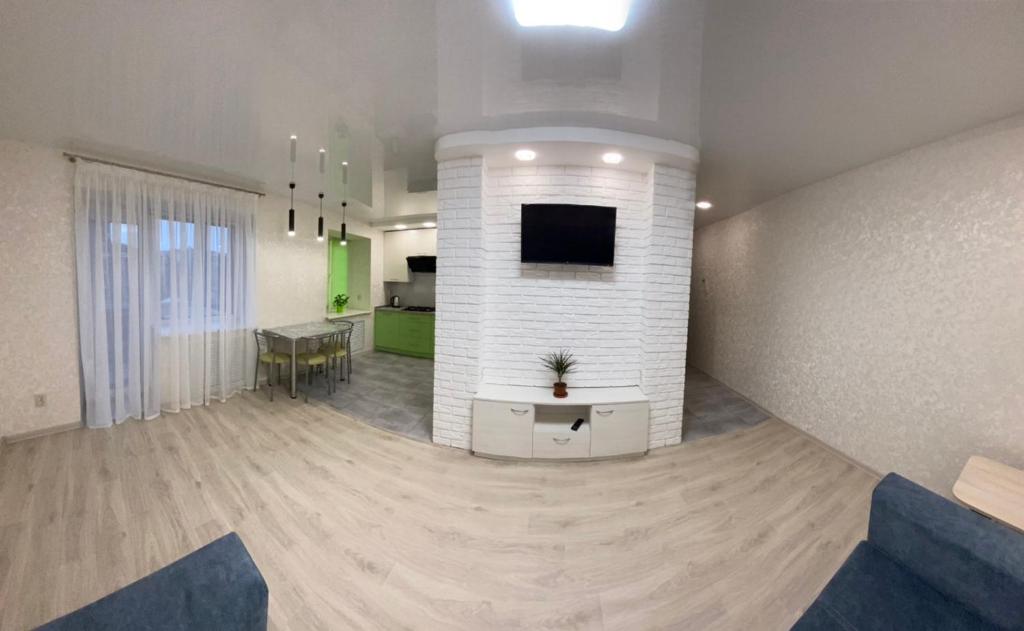 a living room with a tv and a dining room at Suite Mira Avenue Center Двухкомнатная Квартира в центре возле ТЦ ЦУМ in Chernihiv