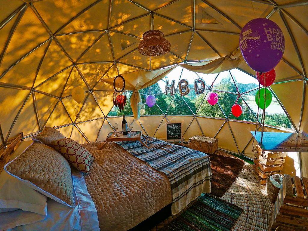 1 dormitorio en una yurta con cama y globos en Alma de Campo Glamping - Laguna de Suesca, en Suesca