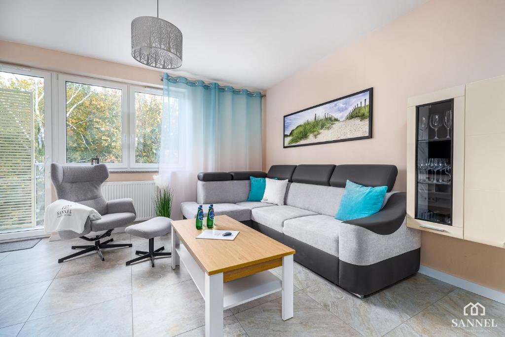 - un salon avec un canapé et une table dans l'établissement Apartament Lazure, à Dziwnówek