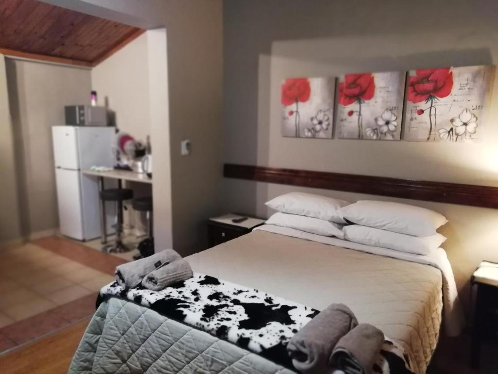 een slaapkamer met een bed met rode rozenschilderijen aan de muur bij Hopetown Accommodation in Hopetown