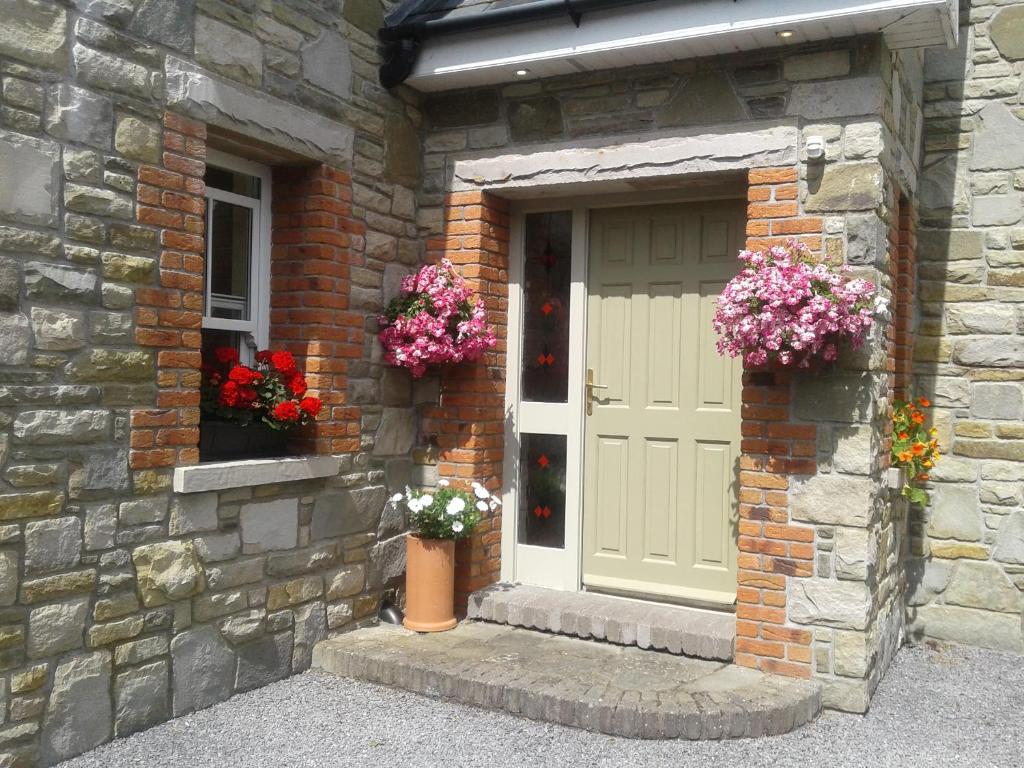 a brick building with a door and flowers on it at Devenish Lodge B&B in Ballinrobe
