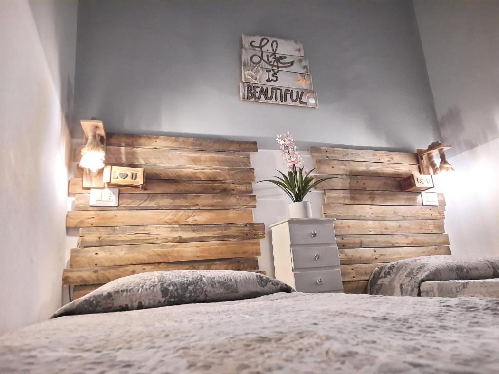 ein Schlafzimmer mit einem Bett und einer Holzwand in der Unterkunft La Casetta in Nardò