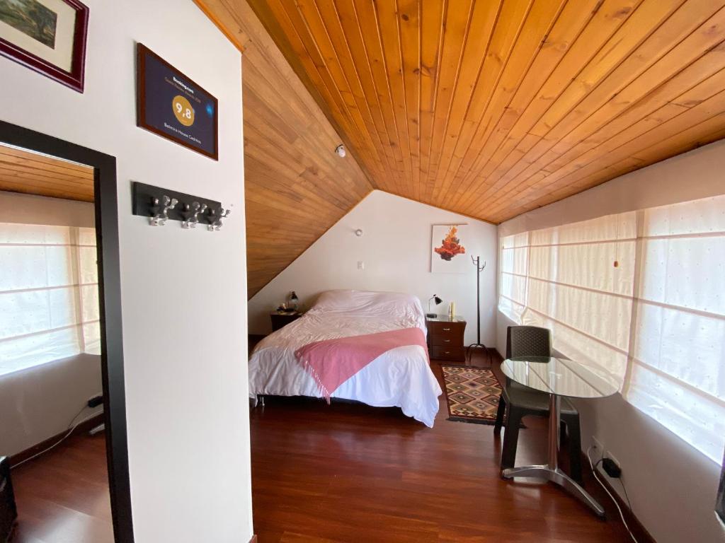 1 dormitorio con cama y techo de madera en Belmira House Cedritos, en Bogotá