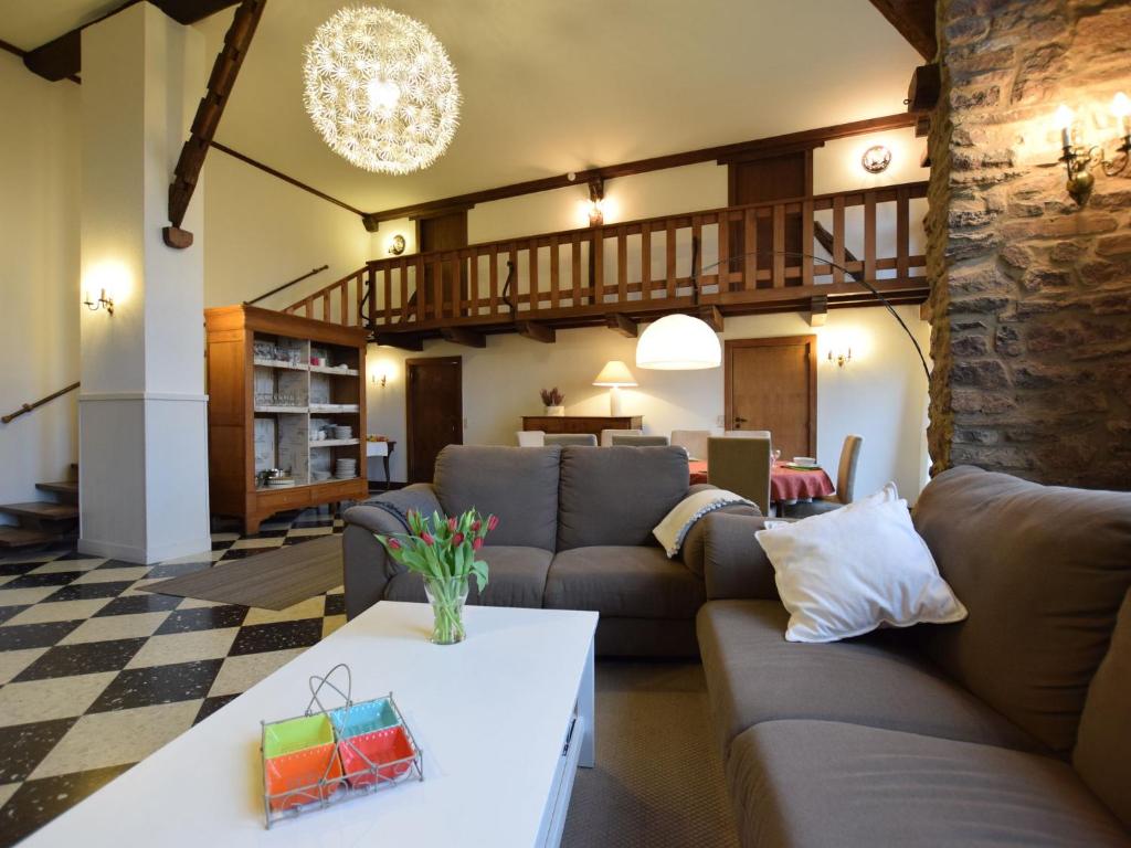 a living room with a couch and a table at Charming house perfect for family holidays in Érezée