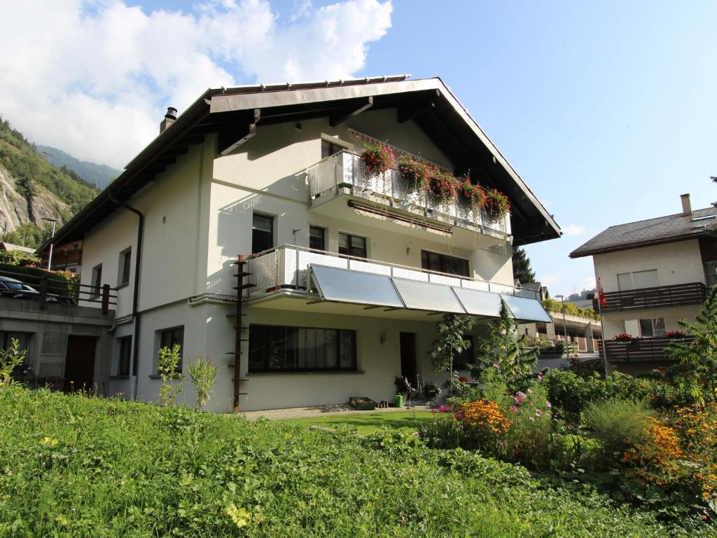 un edificio con un balcón con flores. en holiday home in M rel near the Aletsch ski area, en Mörel