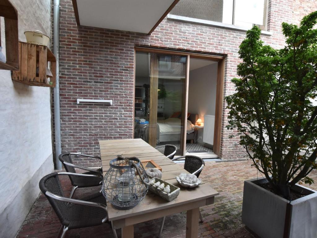 una mesa de madera y sillas en un patio en Studio in Ieper with terrace en Ypres