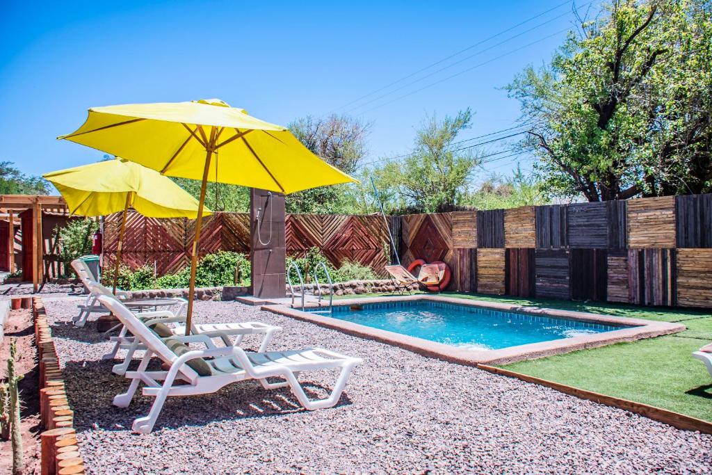 a patio area with umbrellas and a pool at San Pedro Domos in San Pedro de Atacama
