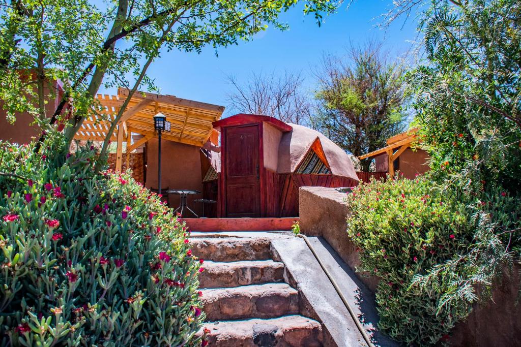 een huis met een rode deur en een yurt bij San Pedro Domos in San Pedro de Atacama