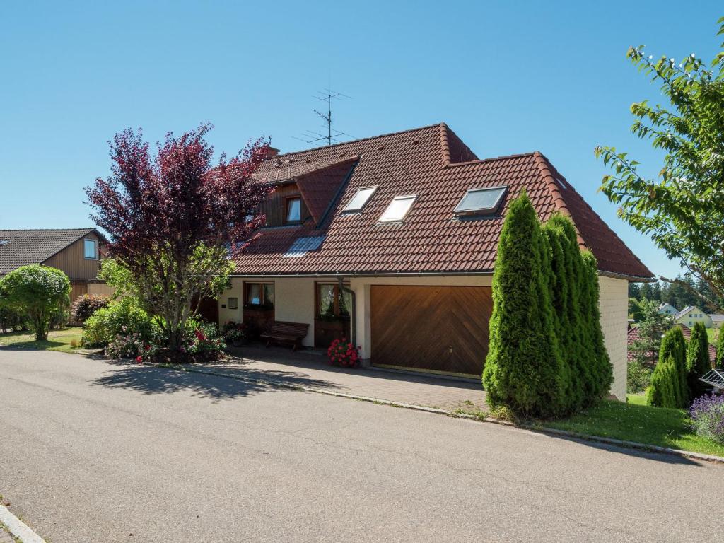 a house with a garage on a street at Holiday flat with balcony in Black Forest in Furtwangen