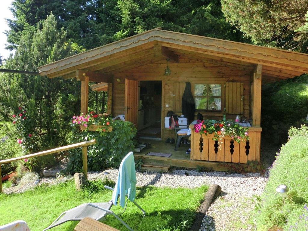 einem Holzschuppen mit einem Tisch und Stühlen im Hof in der Unterkunft Log cabin in Bavaria with covered terrace in Steingaden