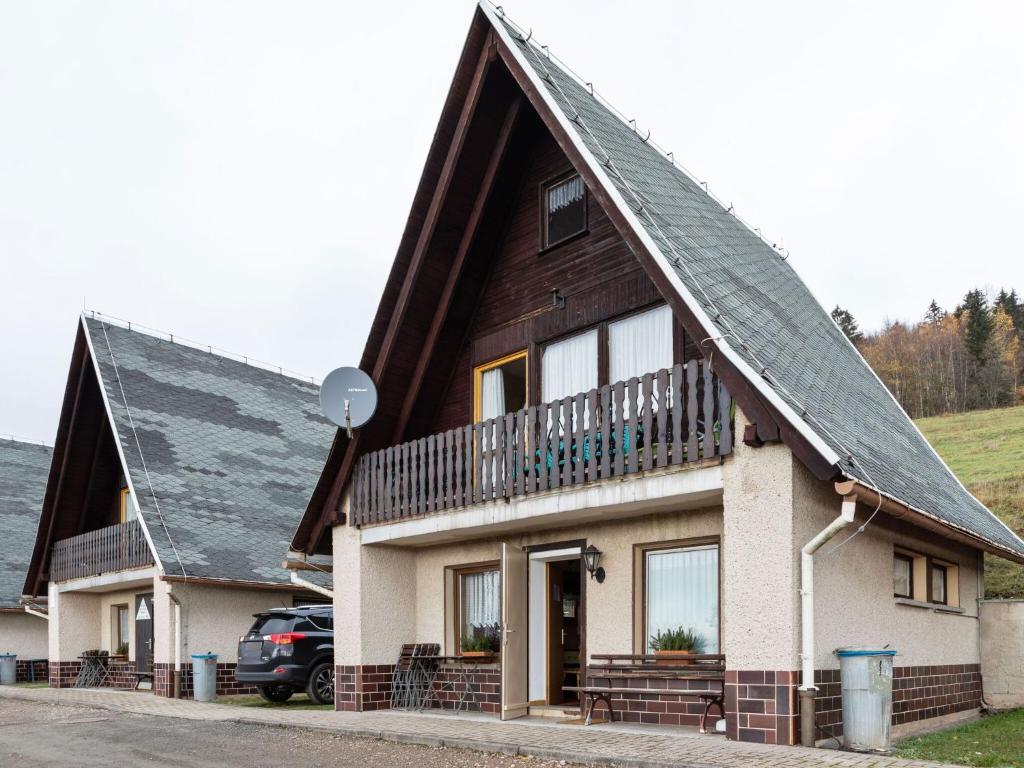 une maison avec un toit en gambrel et un balcon dans l'établissement Holiday cottage with terrace near the Rennsteig, à Bad Liebenstein