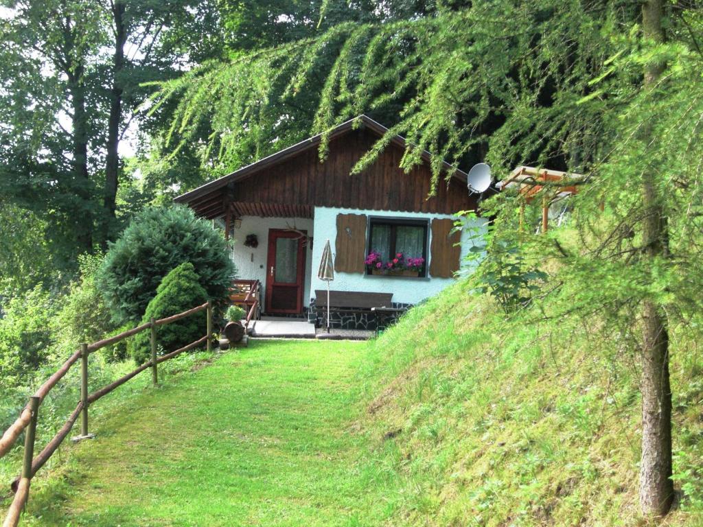 a house on a hill with a fence and a yard at Secluded Holiday Home in Lichtenau with Private Garden in Langenbach