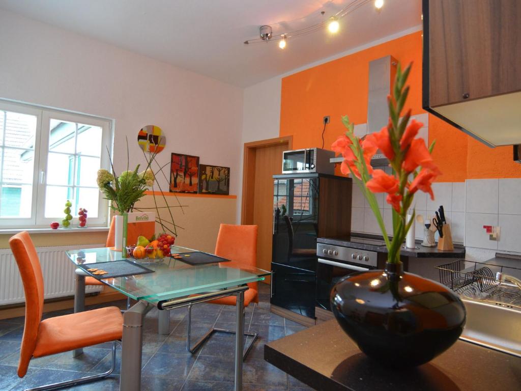 una cucina con tavolo e vaso con fiori di Romantic apartment in Ilmenau a Langewiesen