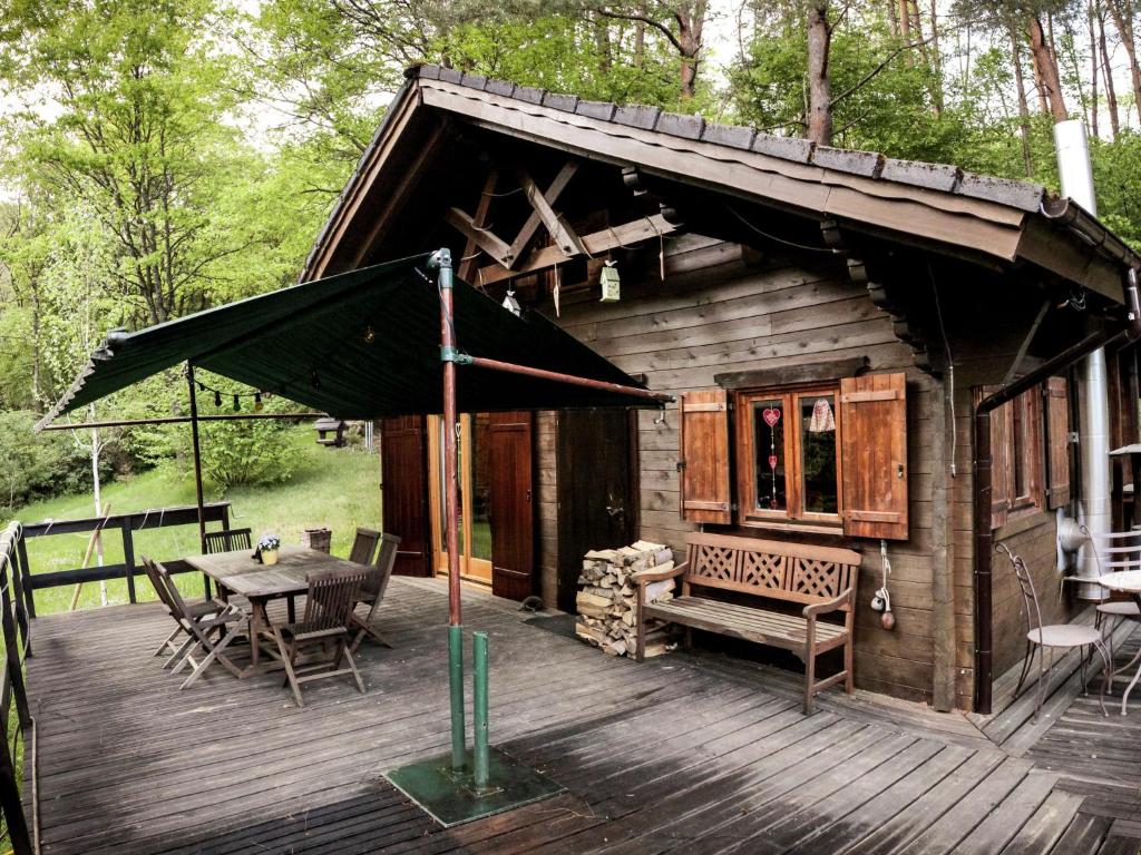 una piccola cabina con tavolo e sedie su una terrazza di Cosy chalet with private sauna in Bousseviller a Bousseviller