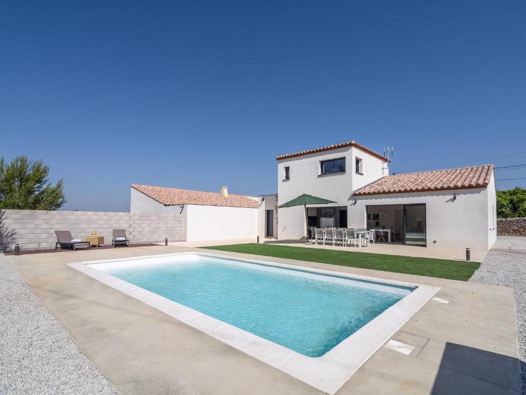 a villa with a swimming pool in front of a house at Holiday Home Beaufort with Private Pool in Beaufort