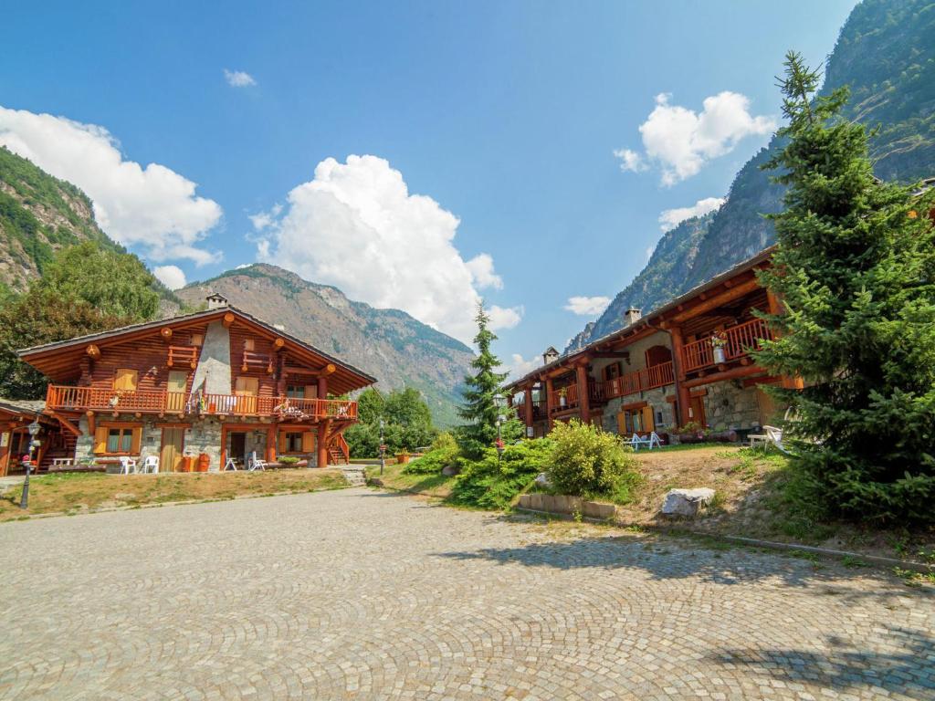 a large wooden building with mountains in the background at Belvilla by OYO GrBe Penta in Antey-Saint-André