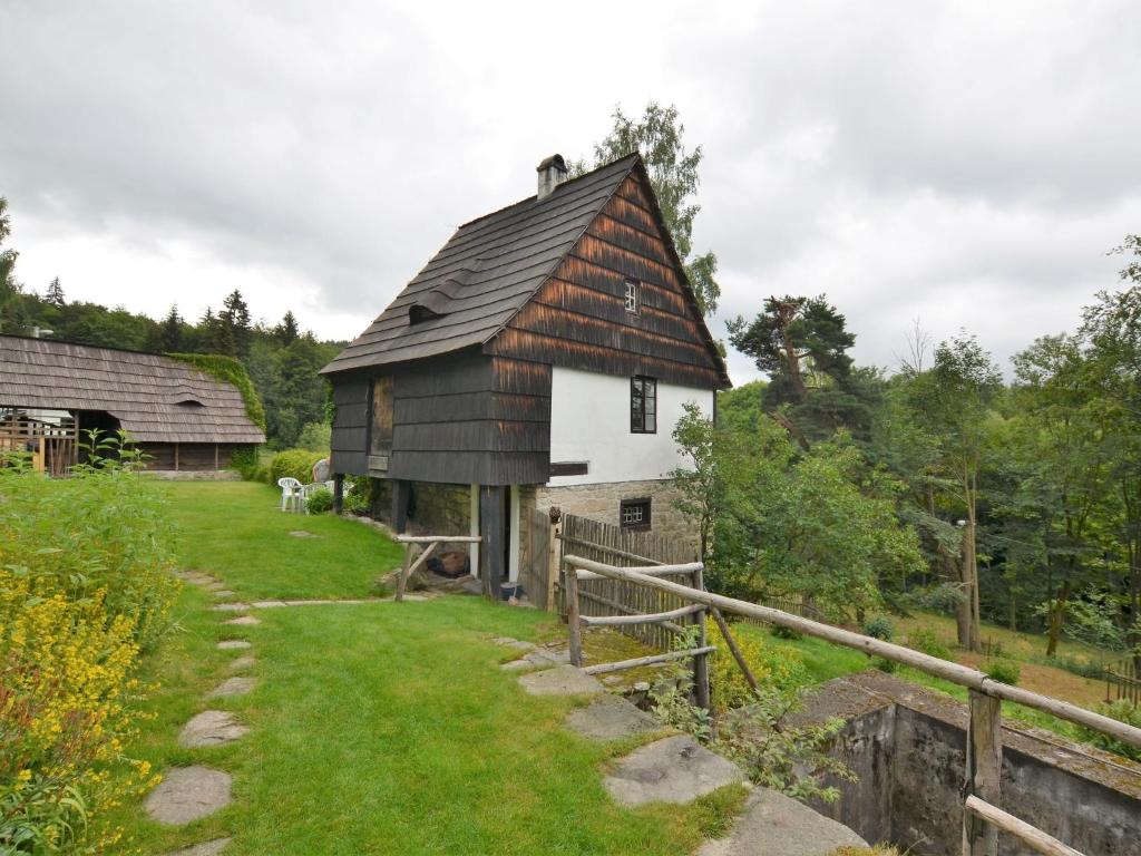 an old barn with a black and white roof at Holiday Home in Nejdek in West Bohemia with garden in Nejdek