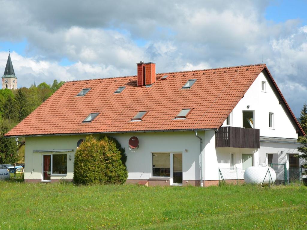 a white house with an orange roof on a field at Apartment in Bohemian with Private Terrace in Dolní Lánov