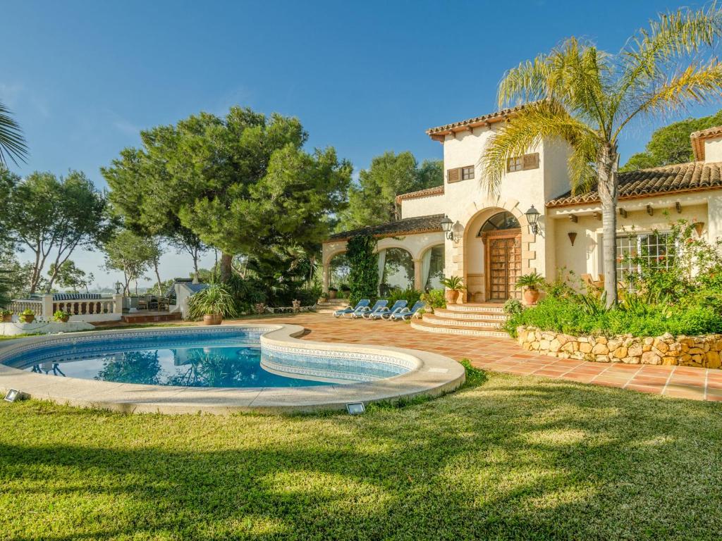 ein Haus mit einem Pool vor einem Hof in der Unterkunft Belvilla by OYO Villa La Brisa in Foyes Blanques