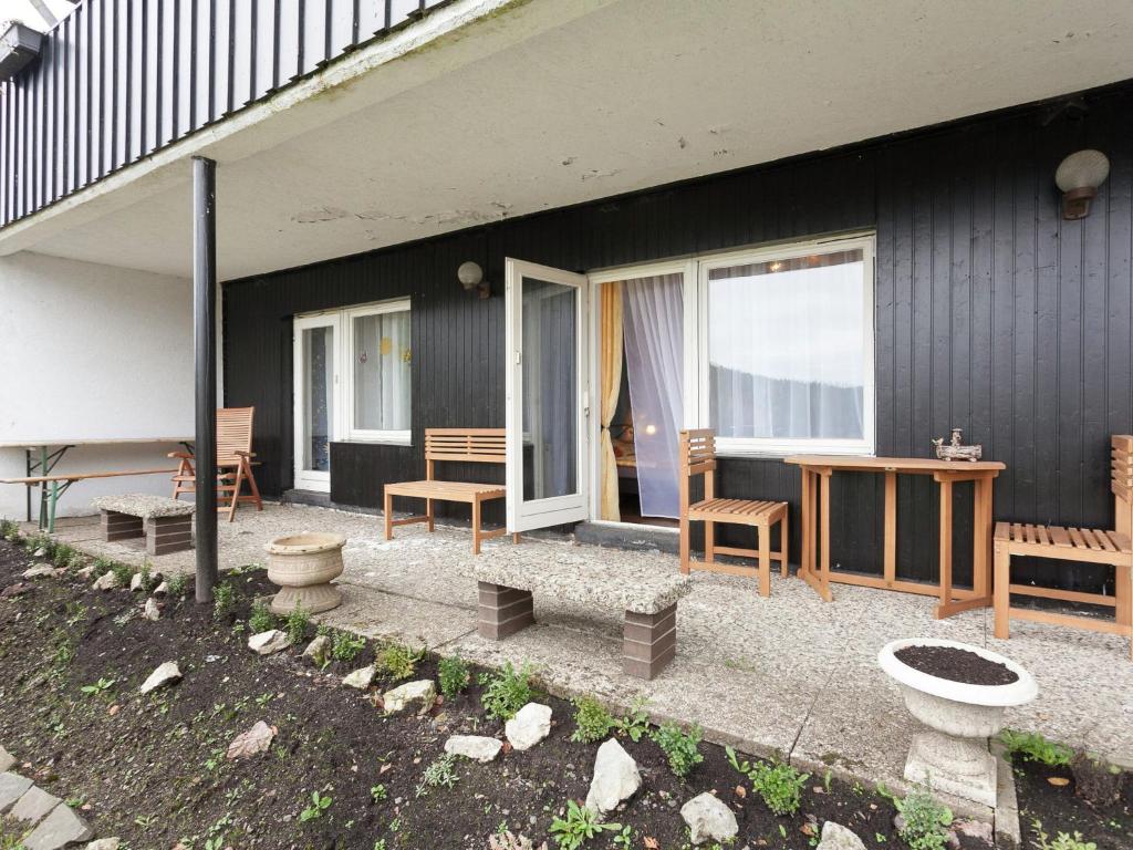 a patio of a house with a table and chairs at Apartment in health and Kneipp resort in the Upper Harz with huge garden in Wildemann