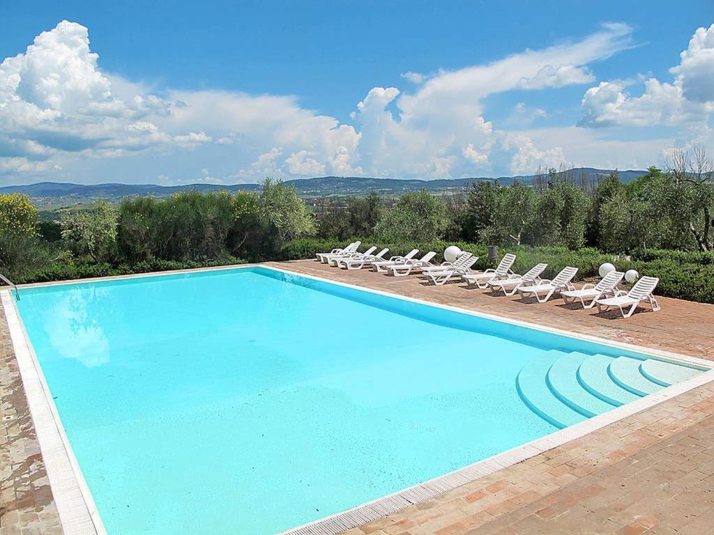 een groot zwembad met ligstoelen bij Belvilla by OYO Garbo in Asciano