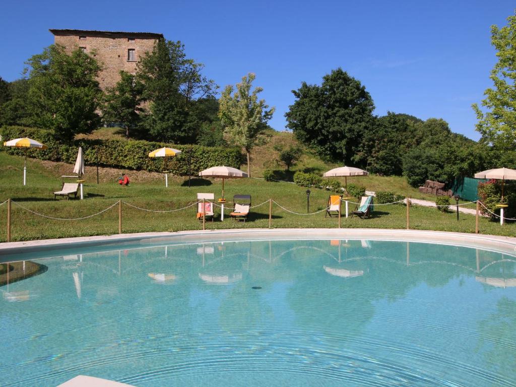 une grande piscine avec des chaises et des parasols dans l'établissement Belvilla by OYO Rosa Bianca, à Apecchio