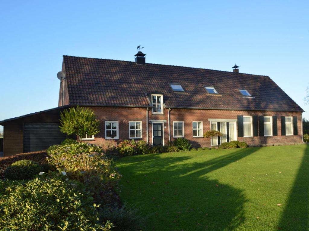 una gran casa de ladrillo rojo con un gran patio en Linked farm in Elsendorp with a recreation barn, en Elsendorp