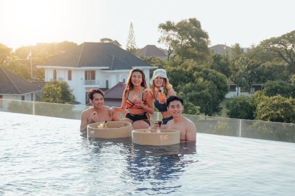 un groupe de personnes assises dans une piscine dans l'établissement Wimarion Hotel Semarang, à Semarang