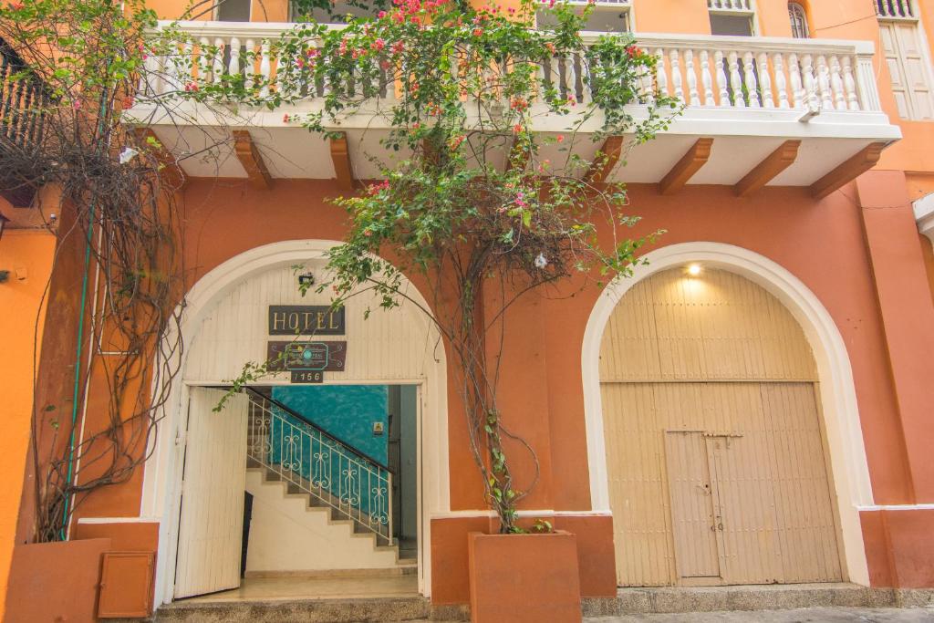 カルタヘナ・デ・インディアスにあるHotel Marie Real Cartagenaの門前の木のあるオレンジ色の建物