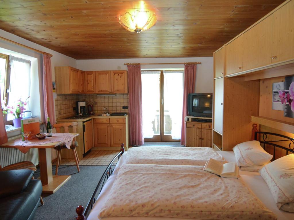 1 Schlafzimmer mit einem großen Bett und einer Küche in der Unterkunft Cosy apartment in Bad Bayersoien with balcony in Bayersoien