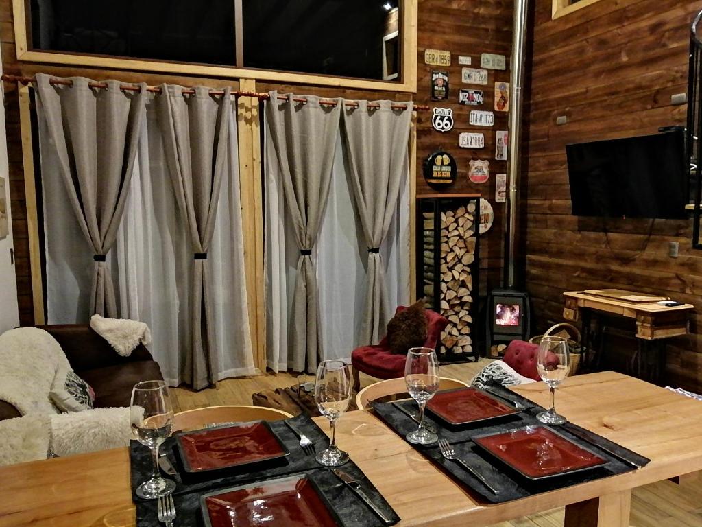 uma sala de estar com uma mesa com copos de vinho em The Loft em Valle Las Trancas